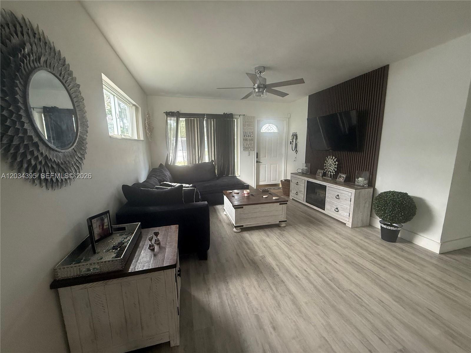 A living room features a dark sectional sofa, a wood coffee table, and a television — 2538 Coolidge St, Hollywood FL 33020, HOLLYWOOD, FL