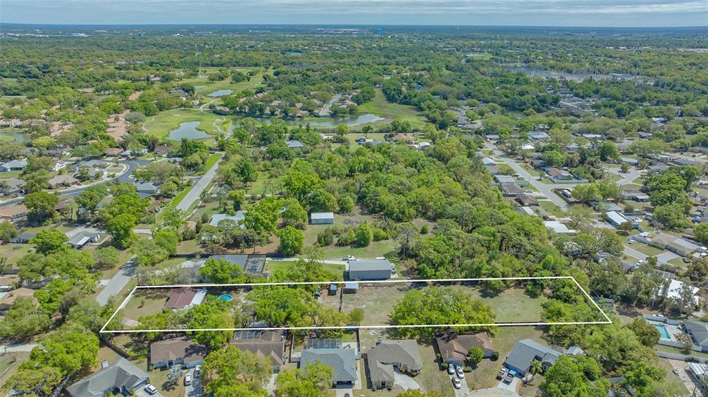 An aerial view shows a large, rectangular residential lot outlined in white amidst suburban homes — 3818 GOCIO ROAD, SARASOTA, FL