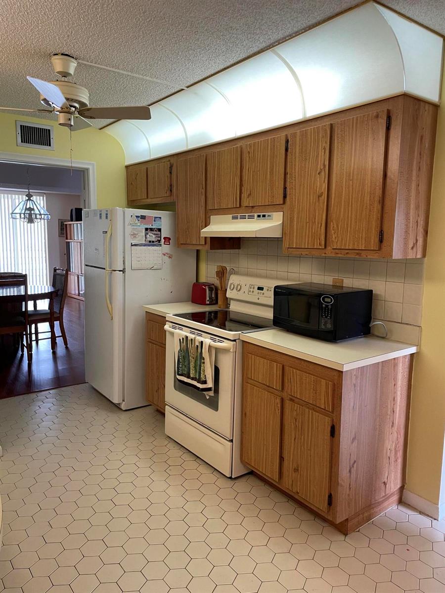 A kitchen with white cabinets, stainless steel appliances, subway tile backsplash, and hexagonal floor tiles — 3286 Arcara Way # 313, Lake Worth FL 33467, LAKE WORTH, FL
