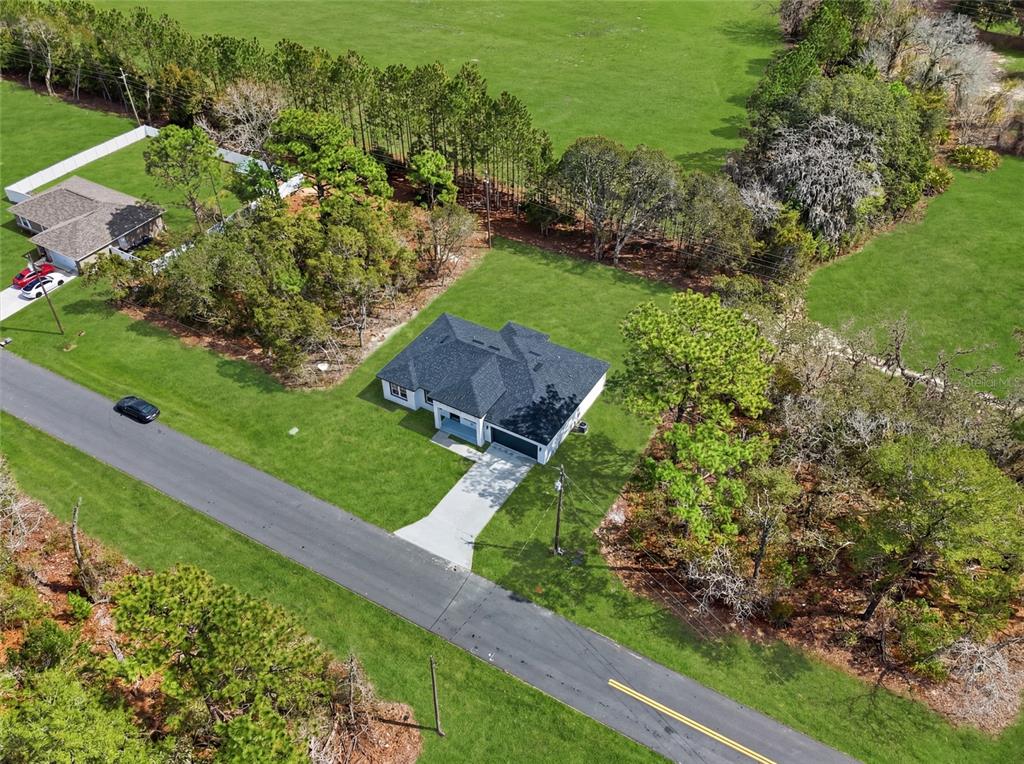 An aerial view shows a single-story house with a dark roof on a grassy lot — 15043 SW 60TH TERRACE, OCALA, FL