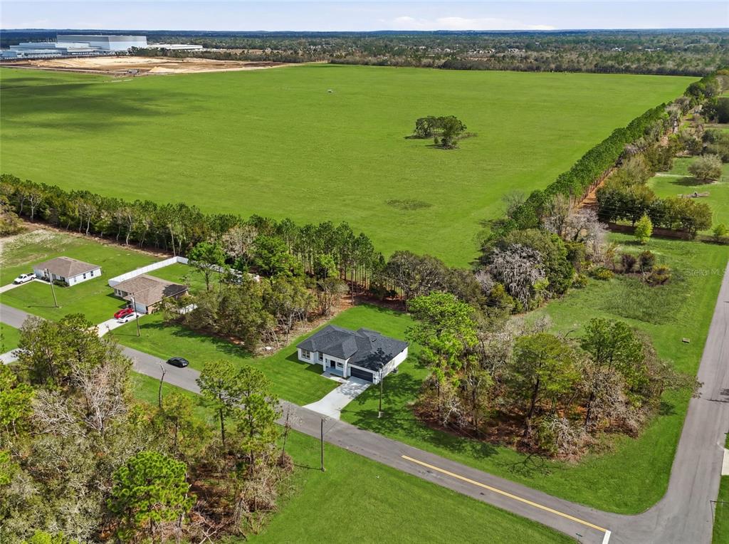 An aerial view shows a single-story house surrounded by trees and a large open field — 15043 SW 60TH TERRACE, OCALA, FL
