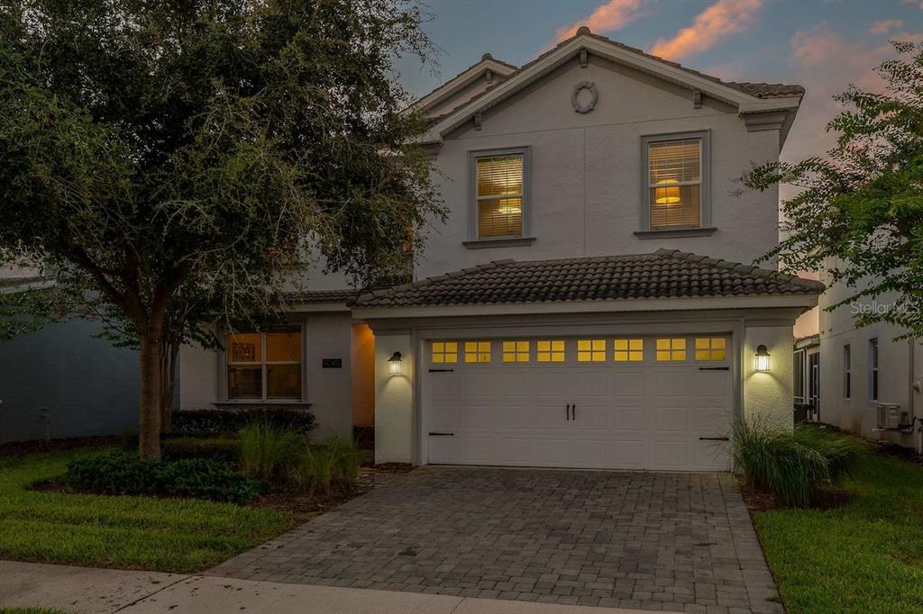 A two-story house with a white stucco exterior, a two-car garage, and a paved driveway — 9045 HAZARD STREET, DAVENPORT, FL