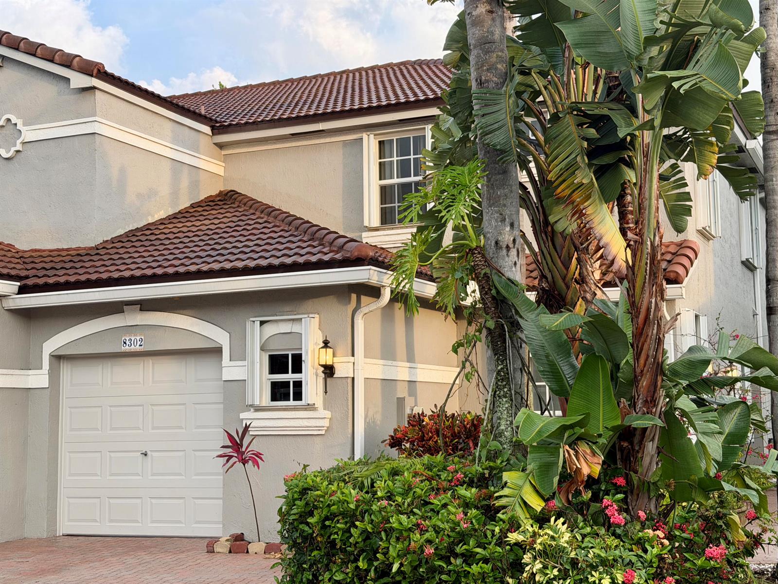 A two-story house with a gray stucco exterior, brown tile roof, and a garage — 8302 Vía Serena, Boca Raton FL 33433, BOCA RATON, FL