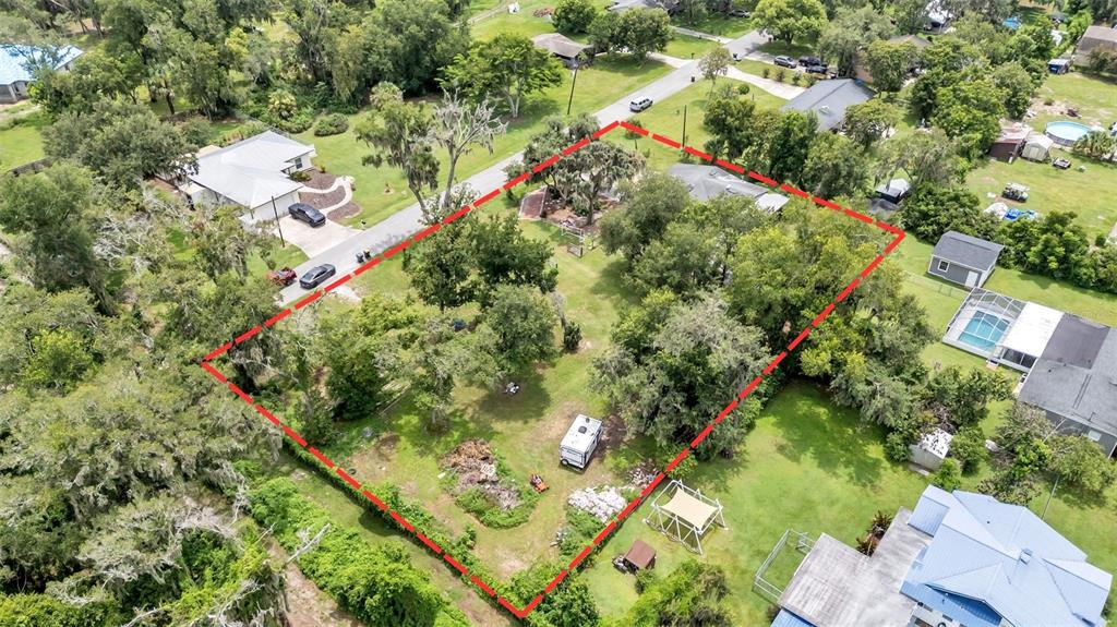 An aerial view shows a rectangular residential lot outlined in red with trees and structures — 7011 DAVIN STREET, LAKELAND, FL