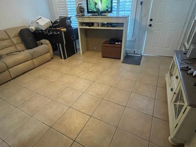 A living room features beige tile flooring, a tan sofa, and a television on a console — 2531 NE 9th Avenue, Pompano Beach FL 33064, POMPANO BEACH, FL
