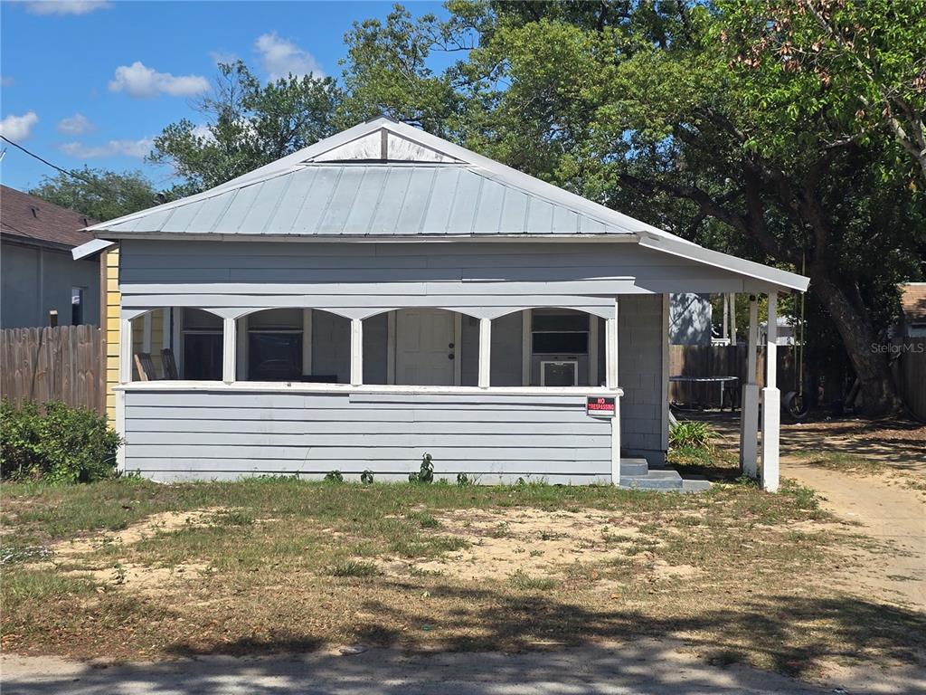 A single-story house with gray horizontal siding and a metal roof features a front porch — 3703 N 51ST STREET, TAMPA, FL