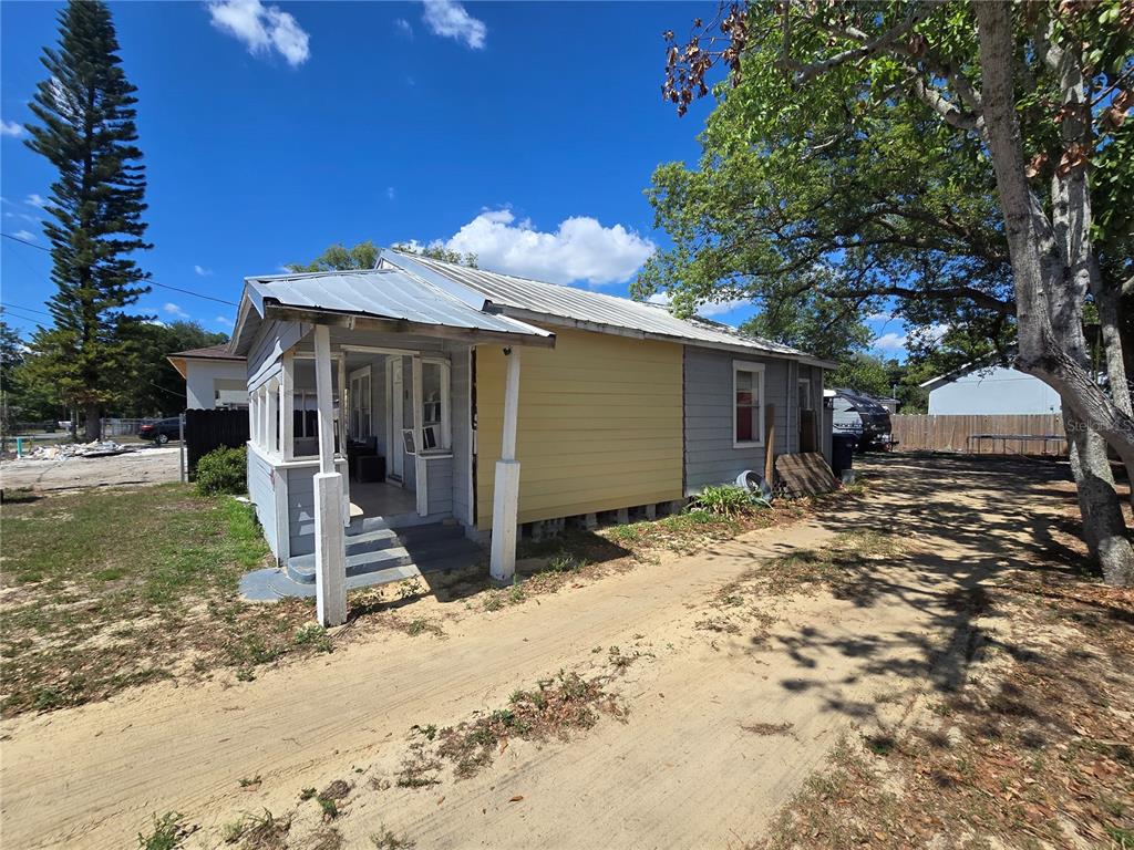 A small, single-story house with a metal roof, a front porch, and mixed-color exterior siding — 3703 N 51ST STREET, TAMPA, FL