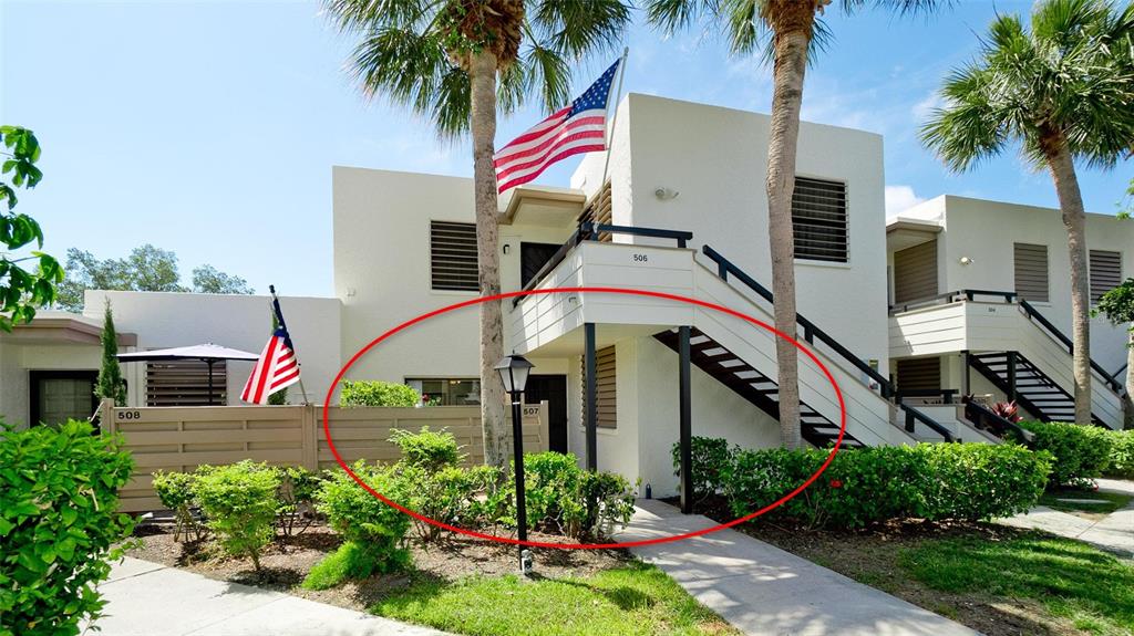 The exterior of a two-story residential building features a ground-level entrance and a wooden fence — 507 LAKESIDE DRIVE UNIT 507, BRADENTON, FL