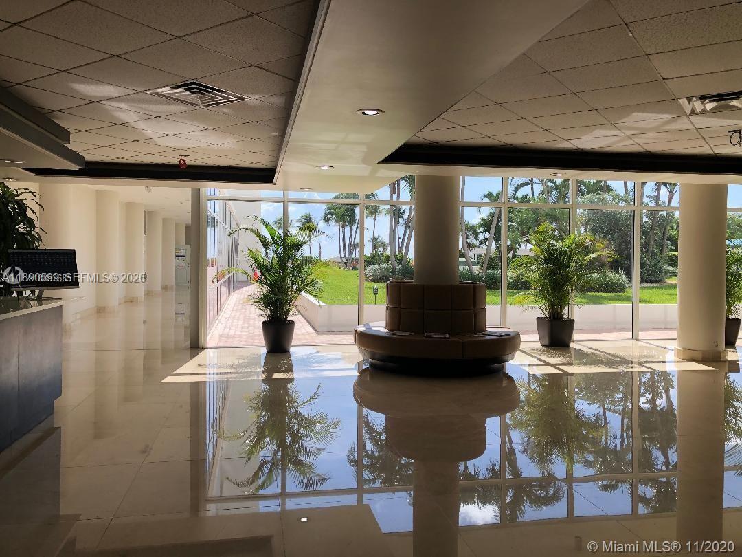 A bright lobby features polished tile floors, a circular seating area, and floor-to-ceiling windows — 5005 Collins Ave # 322, Miami Beach FL 33140, MIAMI BEACH, FL