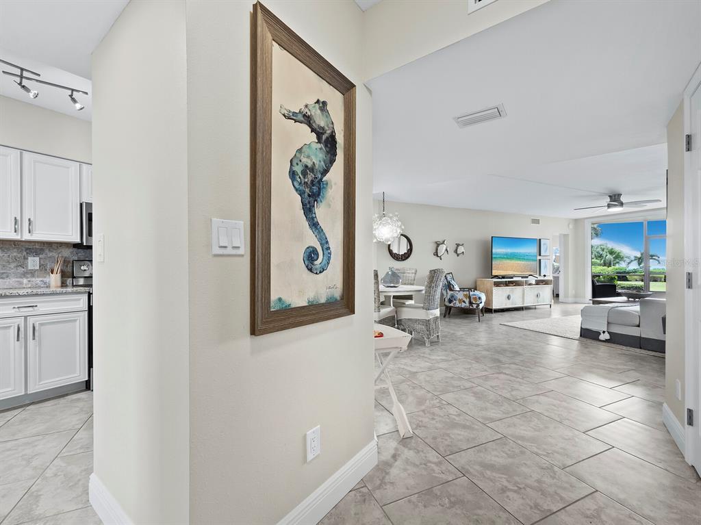 A view from a hallway into an open-concept living area with tile flooring — 4825 GULF OF MEXICO DRIVE UNIT 105, LONGBOAT KEY, FL