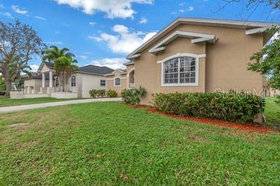 A tan, single-story house with a front lawn and a neighboring home in the background — 7380 PEBBLE BEACH LANE, SEMINOLE, FL