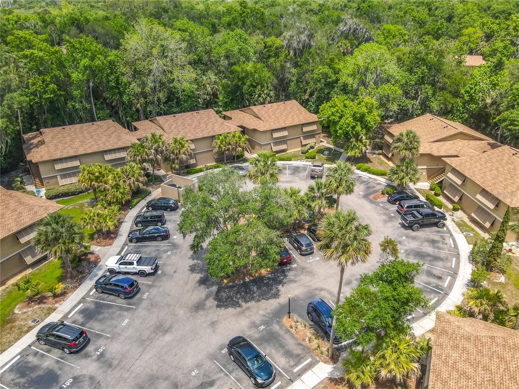 An aerial view shows a multi-unit apartment complex with a central parking lot — 110 CYPRESS WOODS COURT UNIT 7D, DELTONA, FL
