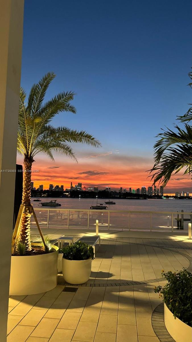 A sunset view of a city skyline over water from a paved outdoor patio — 1000 West Ave, Miami Beach FL 33139, MIAMI BEACH, FL