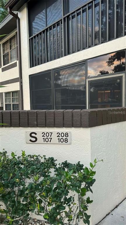 The exterior of a multi-story apartment building features a screened balcony and unit numbers — 19505 QUESADA AVENUE UNIT S107, PORT CHARLOTTE, FL