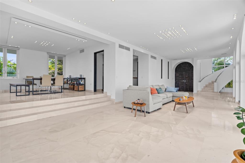A spacious living and dining area features white walls, marble floors, and a curved staircase — 7 LA ROCA STREET BEVERLY HILLS, GUAYNABO, PR