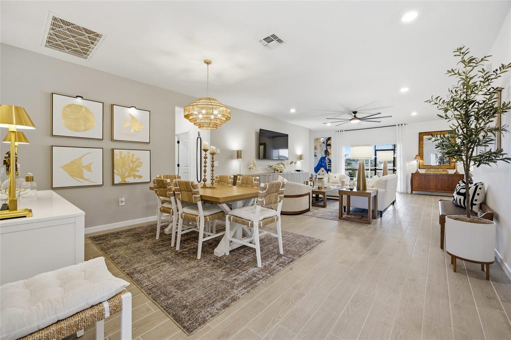 An open-concept living and dining area features light wood-look tile flooring and neutral decor — 8946 SW 67TH AVENUE, OCALA, FL