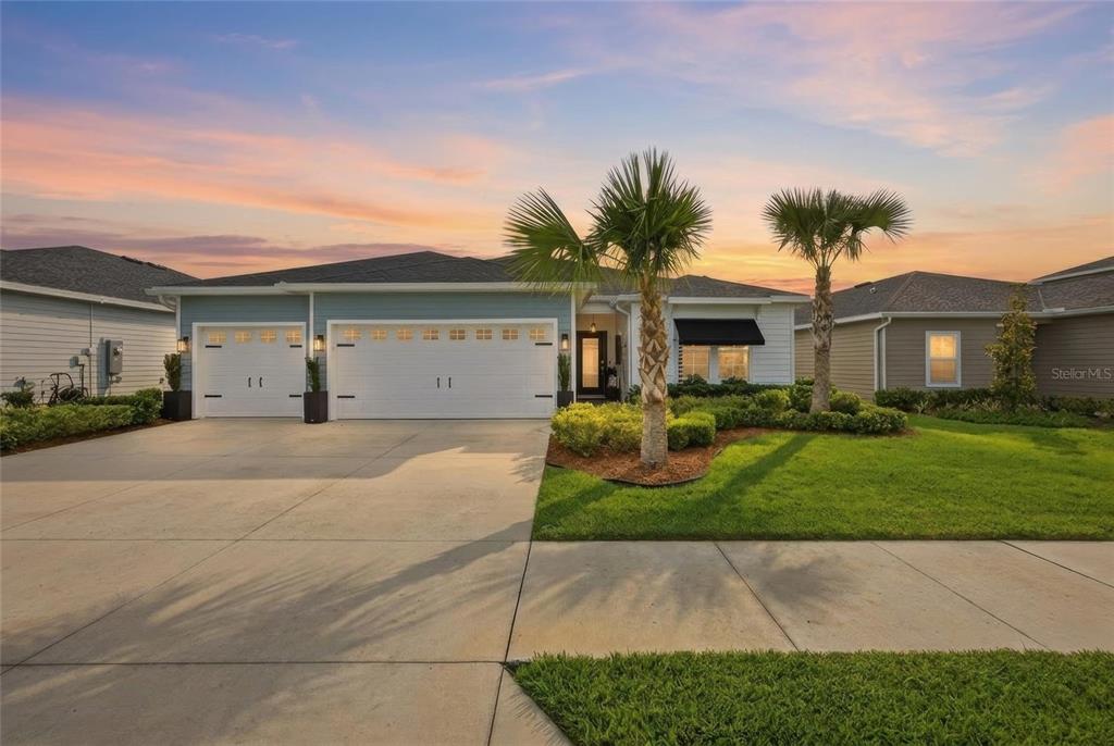 A single-story house with a three-car garage, palm trees, and a landscaped front yard — 8946 SW 67TH AVENUE, OCALA, FL