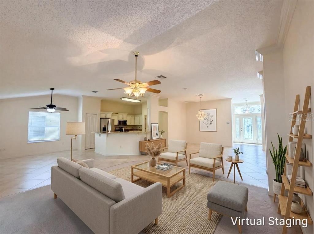 A living room with tile and carpet flooring, a ceiling fan, and virtual furniture staging — 1422 SEGOVIA PLACE, THE VILLAGES, FL