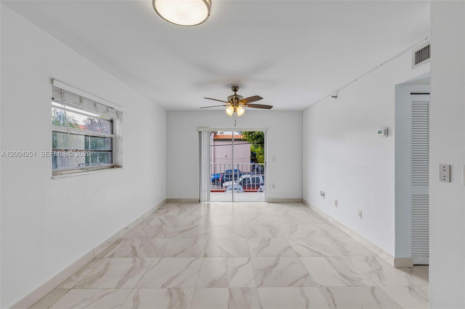 An elevated balcony with white tiled flooring overlooks a parking lot and street — 140 NW 14th Ave # 9, Miami FL 33125, MIAMI, FL