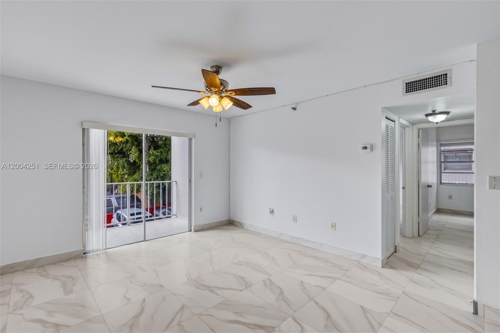 A galley kitchen features white cabinets, black countertops, stainless steel appliances, and a window — 140 NW 14th Ave # 9, Miami FL 33125, MIAMI, FL