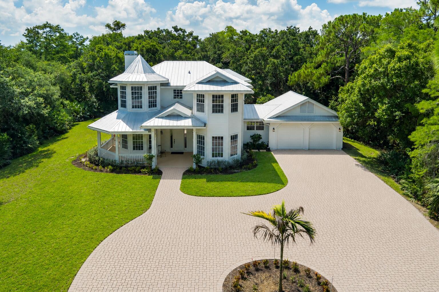 An aerial view of a white two-story house with a metal roof and paved driveway — 1001 SE Ranch Road, Jupiter FL 33478, JUPITER, FL