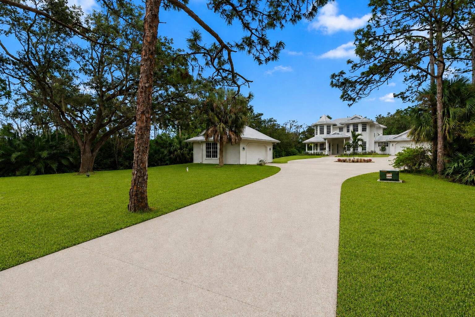 A white two-story house with a detached garage and a paved circular driveway — 1001 SE Ranch Road, Jupiter FL 33478, JUPITER, FL