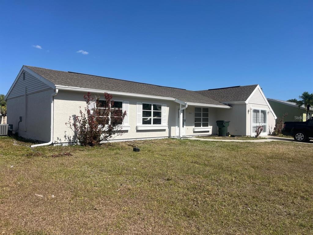 A single-story house with a light-colored exterior, a shingled roof, and a grassy front yard — 5052 TREKELL STREET, NORTH PORT, FL