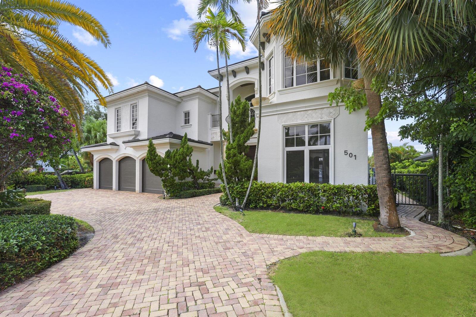 A two-story white stucco house features a brick paver driveway and a three-car garage — 501 Golden Harbour Drive, Boca Raton FL 33432, BOCA RATON, FL