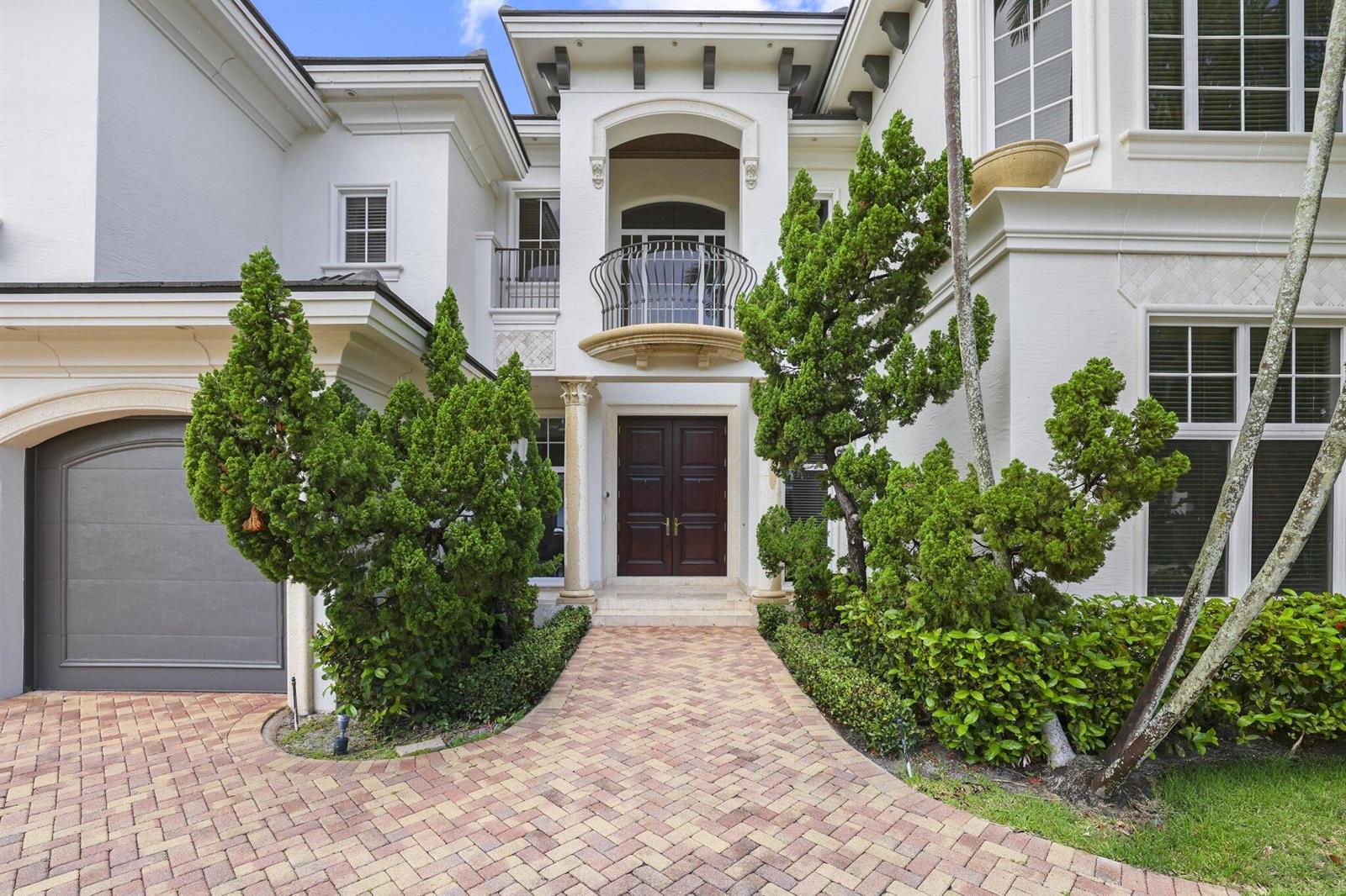 A two-story white house features a dark wood double door entrance and a brick walkway — 501 Golden Harbour Drive, Boca Raton FL 33432, BOCA RATON, FL