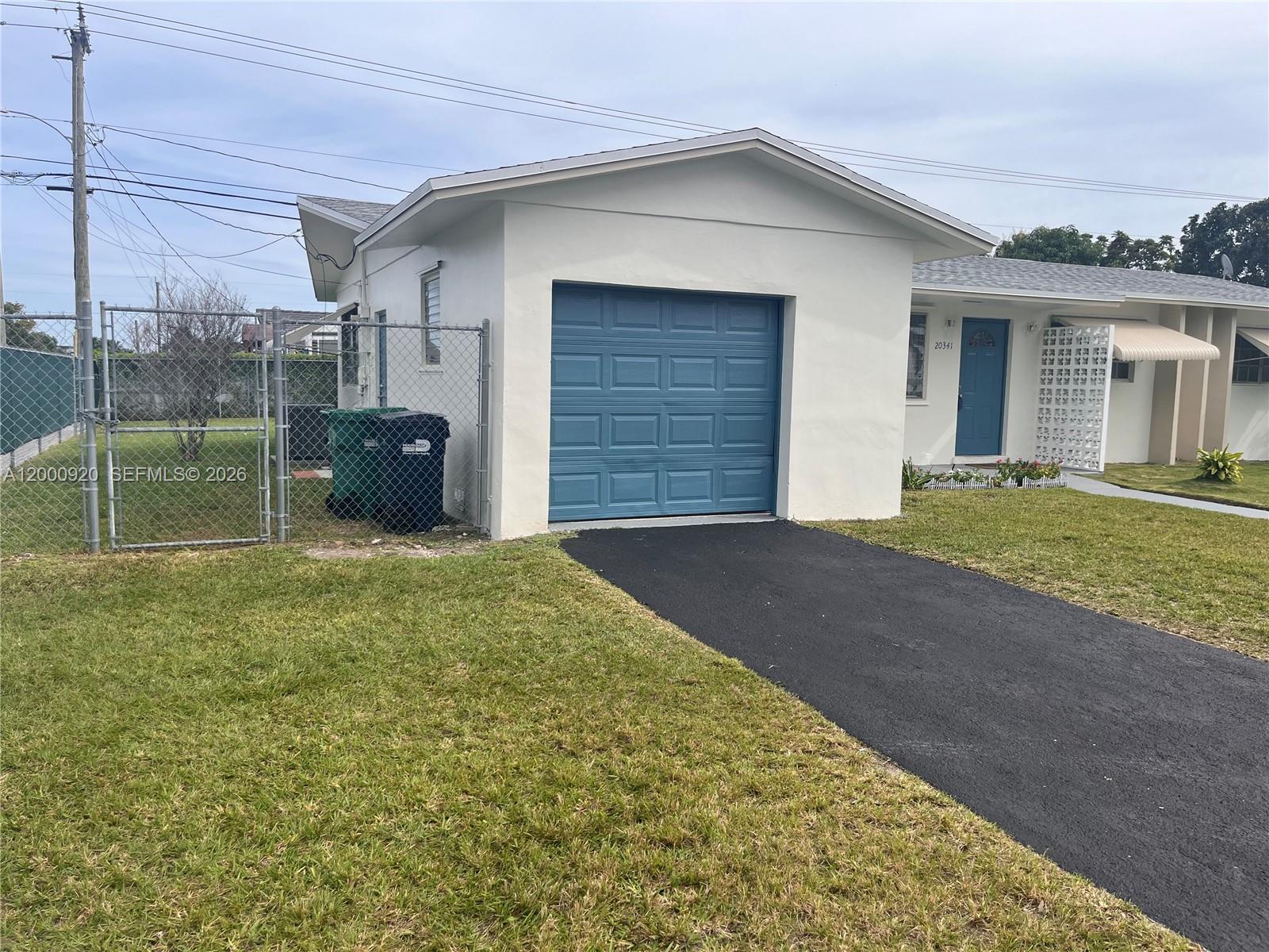 A white house features a blue garage door, a matching blue front door, and a driveway — 20341 SW 117th Ave, Miami FL 33177, MIAMI, FL