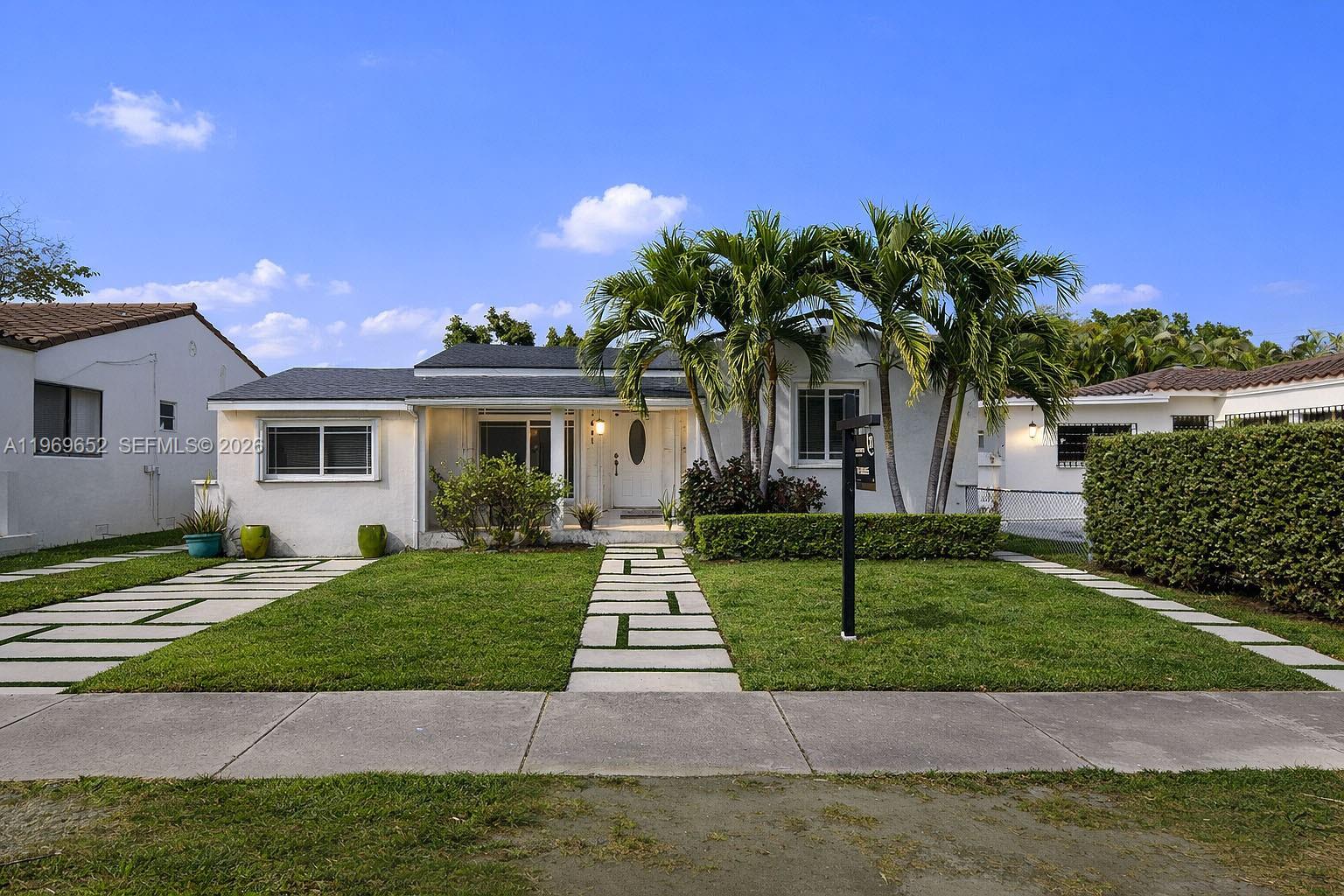 A white single-story house features a paved walkway, palm trees, and a manicured lawn — 1611 SW 21st St, Miami FL 33145, MIAMI, FL