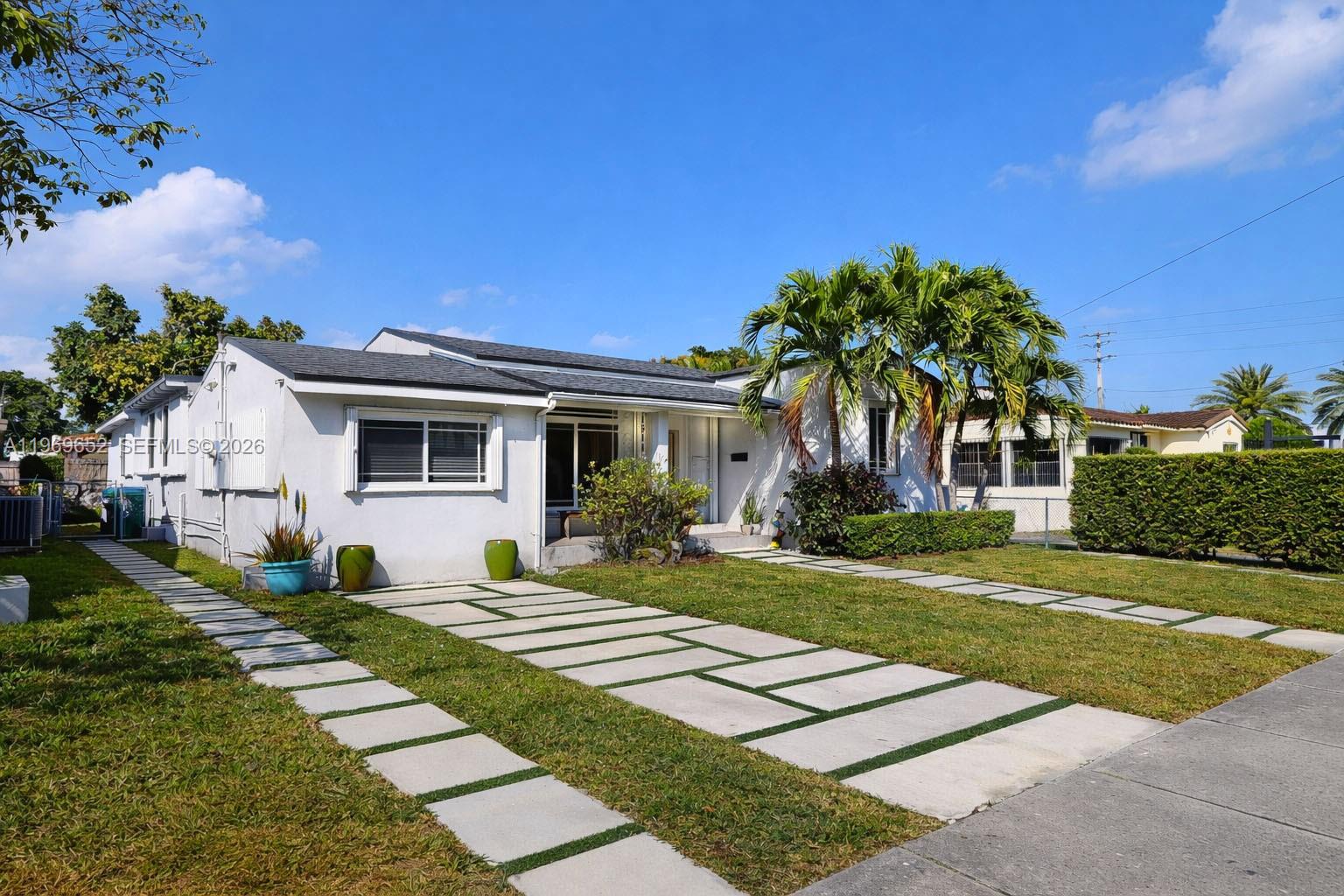 A single-story white house features a modern concrete paver driveway and palm trees — 1611 SW 21st St, Miami FL 33145, MIAMI, FL