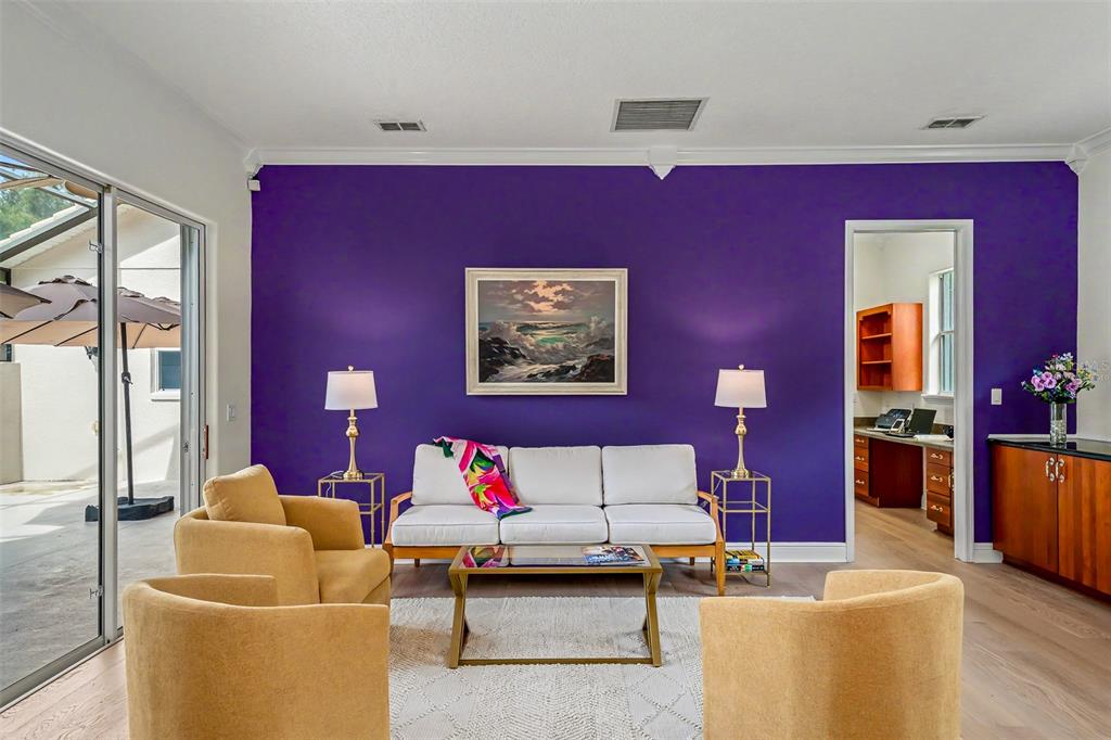 A living room features a vibrant purple accent wall, a white sofa, and yellow armchairs — 522 NEWHALL LANE, DEBARY, FL