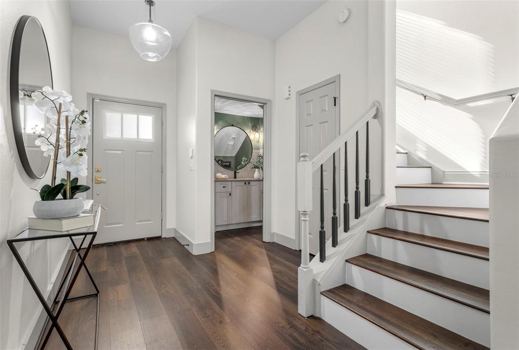 An entryway features dark wood flooring, a staircase with white risers, and a front door — 7032 SOMERTON BOULEVARD UNIT 54, ORLANDO, FL