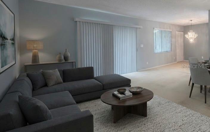 A living room features a gray sectional sofa, a round coffee table, and vertical blinds — 729 MIDWAY DRIVE UNIT B, OCALA, FL