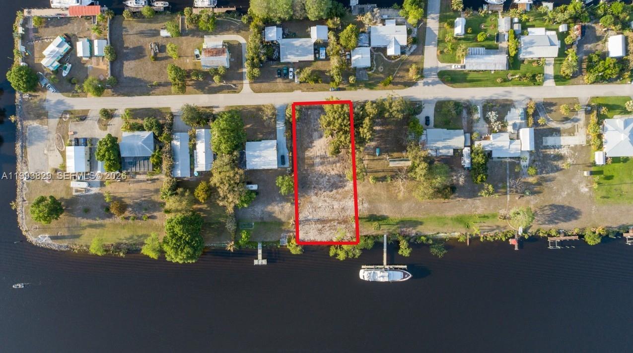 An aerial view shows a rectangular vacant waterfront lot outlined in red — 1035 W Anchor Lane, Moore Haven FL 33471, MOORE HAVEN, FL
