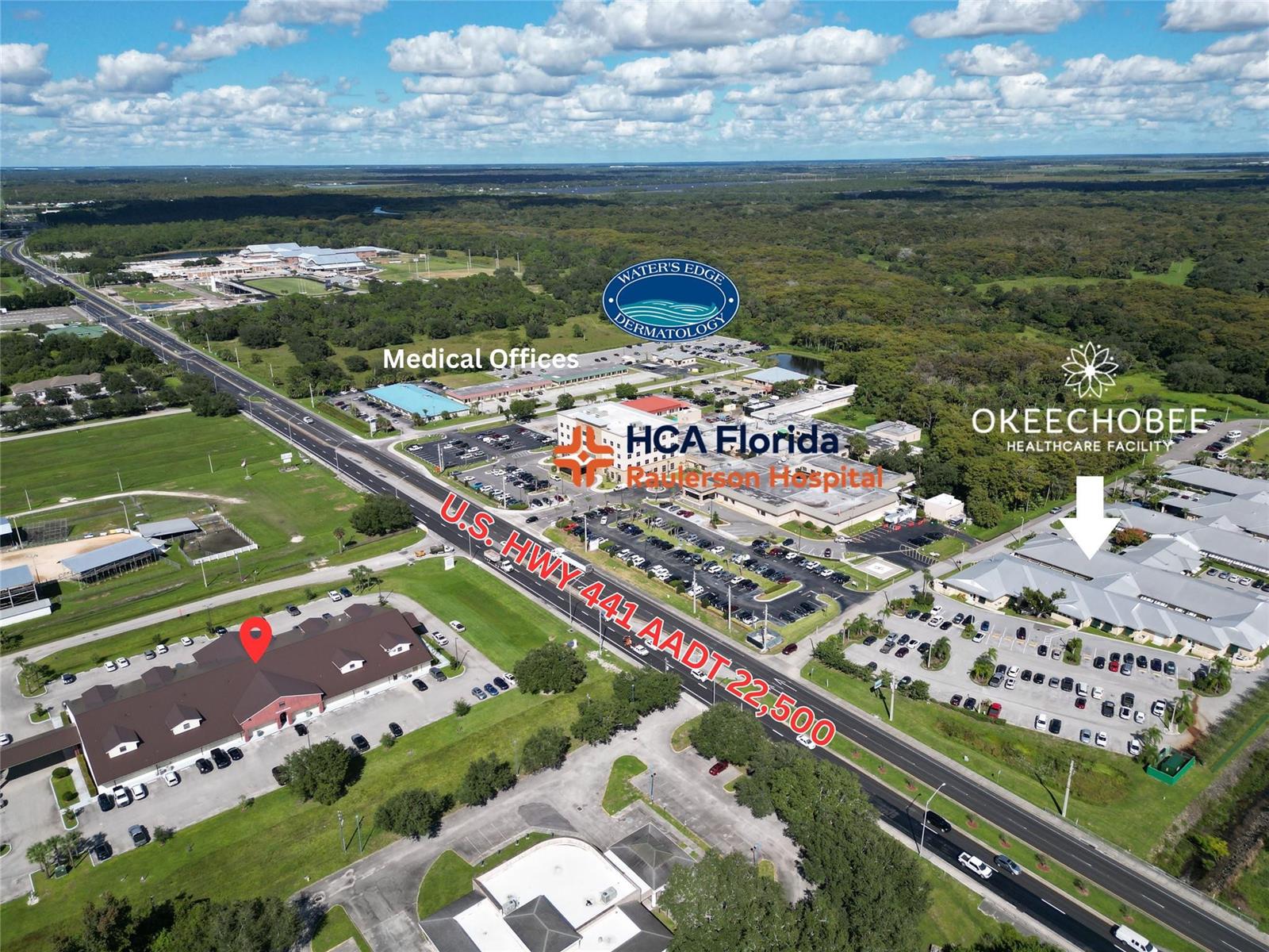 This aerial view shows a commercial area with a hospital, medical offices, and highway — 1713 US Highway 441 # F, Okeechobee FL 34972, OKEECHOBEE, FL