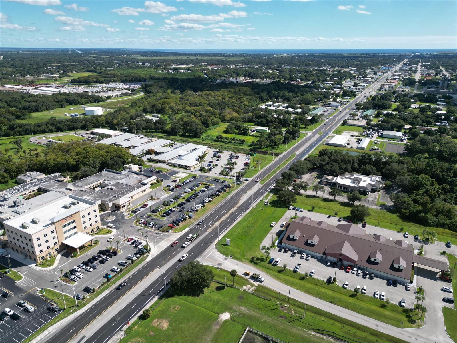 An aerial view shows a commercial complex with parking lots and a highway — 1713 US Highway 441 # F, Okeechobee FL 34972, OKEECHOBEE, FL