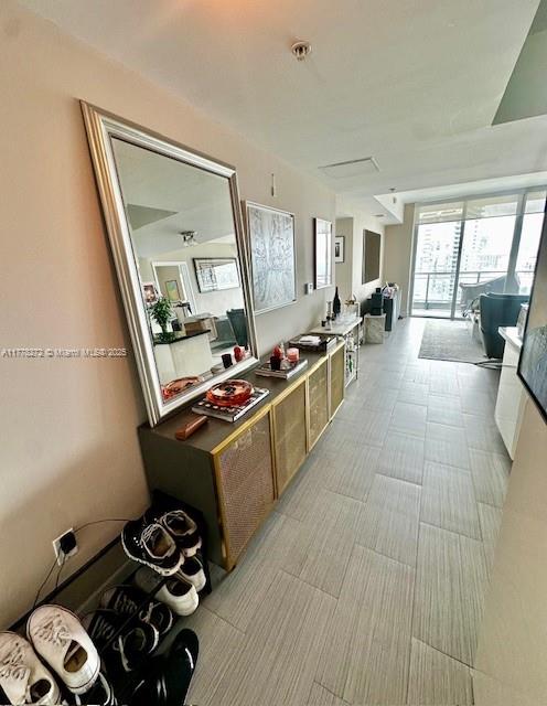 A hallway features a large mirror above a wooden cabinet and a shoe rack below — 92 SW 3rd St # 4104, Miami FL 33130, MIAMI, FL
