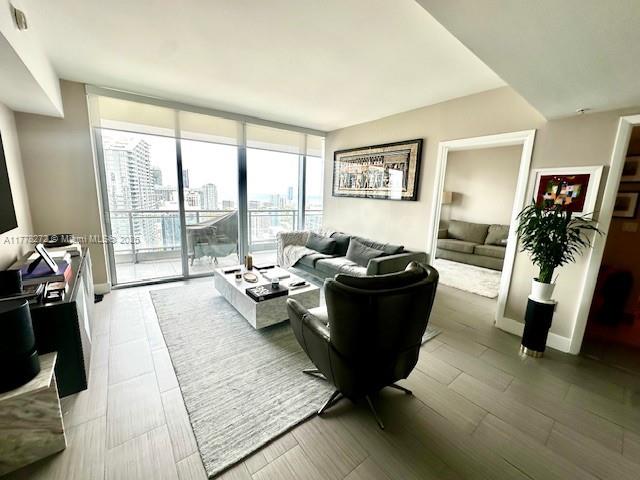 A modern living room features floor-to-ceiling windows, a gray sofa, and a leather armchair — 92 SW 3rd St # 4104, Miami FL 33130, MIAMI, FL
