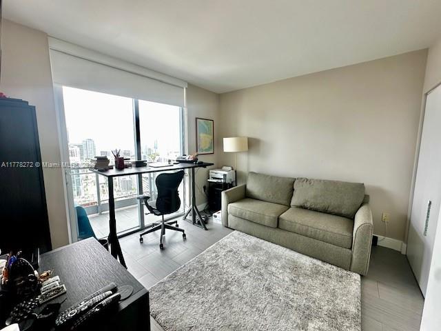 A home office features a desk, an ergonomic chair, and a sofa on a rug — 92 SW 3rd St # 4104, Miami FL 33130, MIAMI, FL