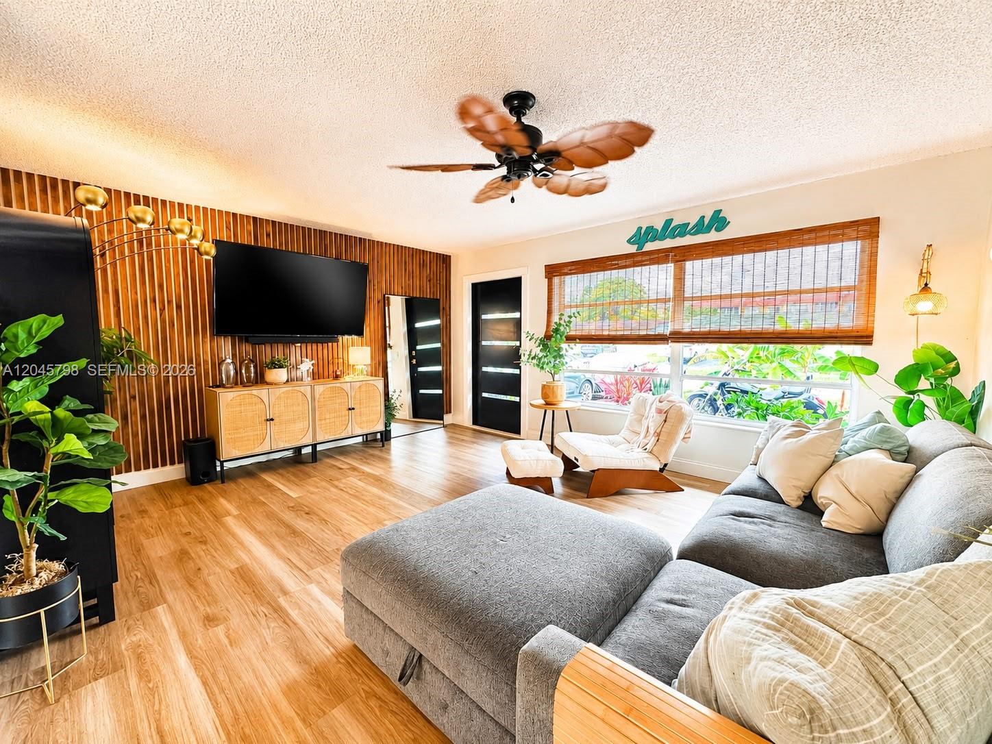 A living room features wood-slat walls, a large gray sectional, and a tropical ceiling fan — 9160 NW 26th Pl, Sunrise FL 33322, SUNRISE, FL