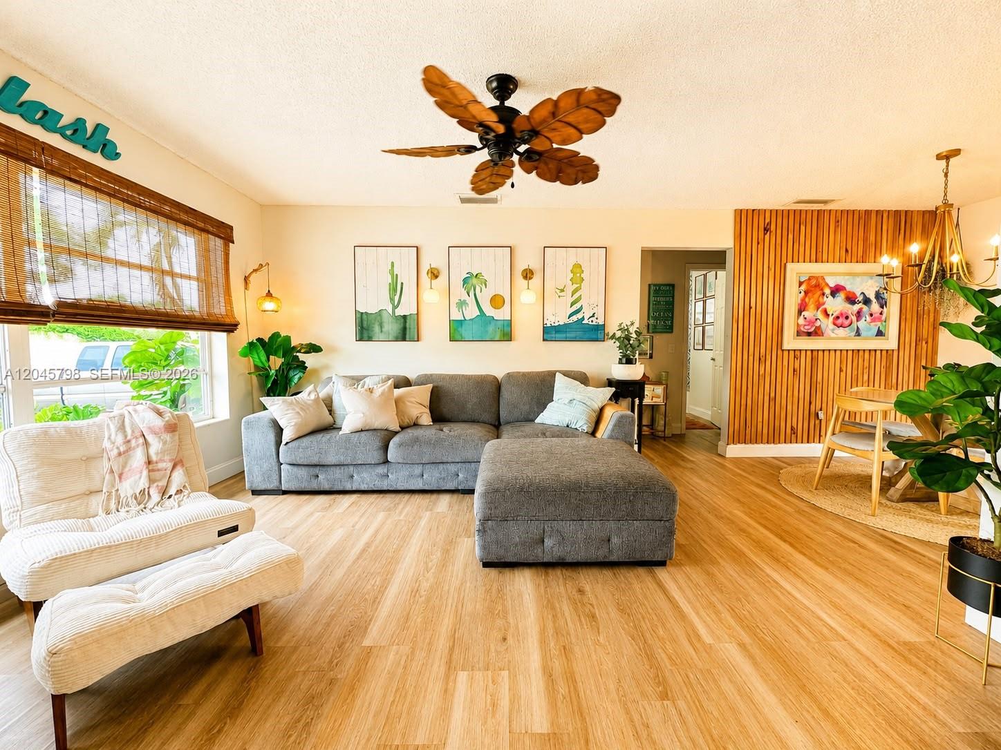 A living room features a grey sectional sofa, wood-slat accent wall, and palm-leaf ceiling fan — 9160 NW 26th Pl, Sunrise FL 33322, SUNRISE, FL