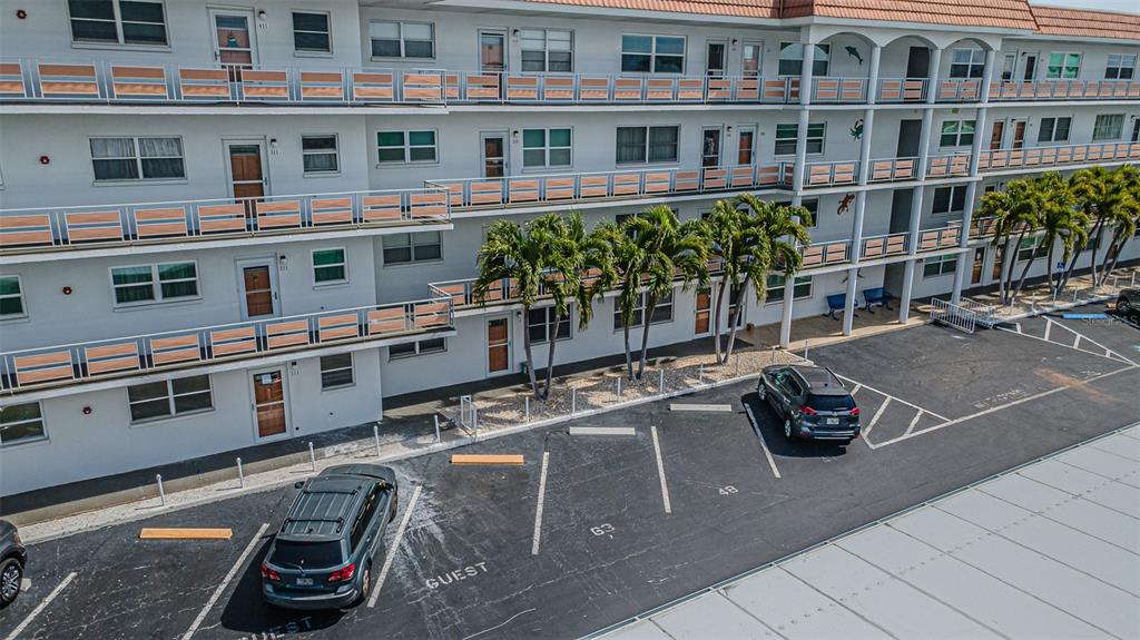An aerial view shows a multi-story apartment building with exterior walkways and a parking lot — 3128 59TH STREET S UNIT 110, GULFPORT, FL