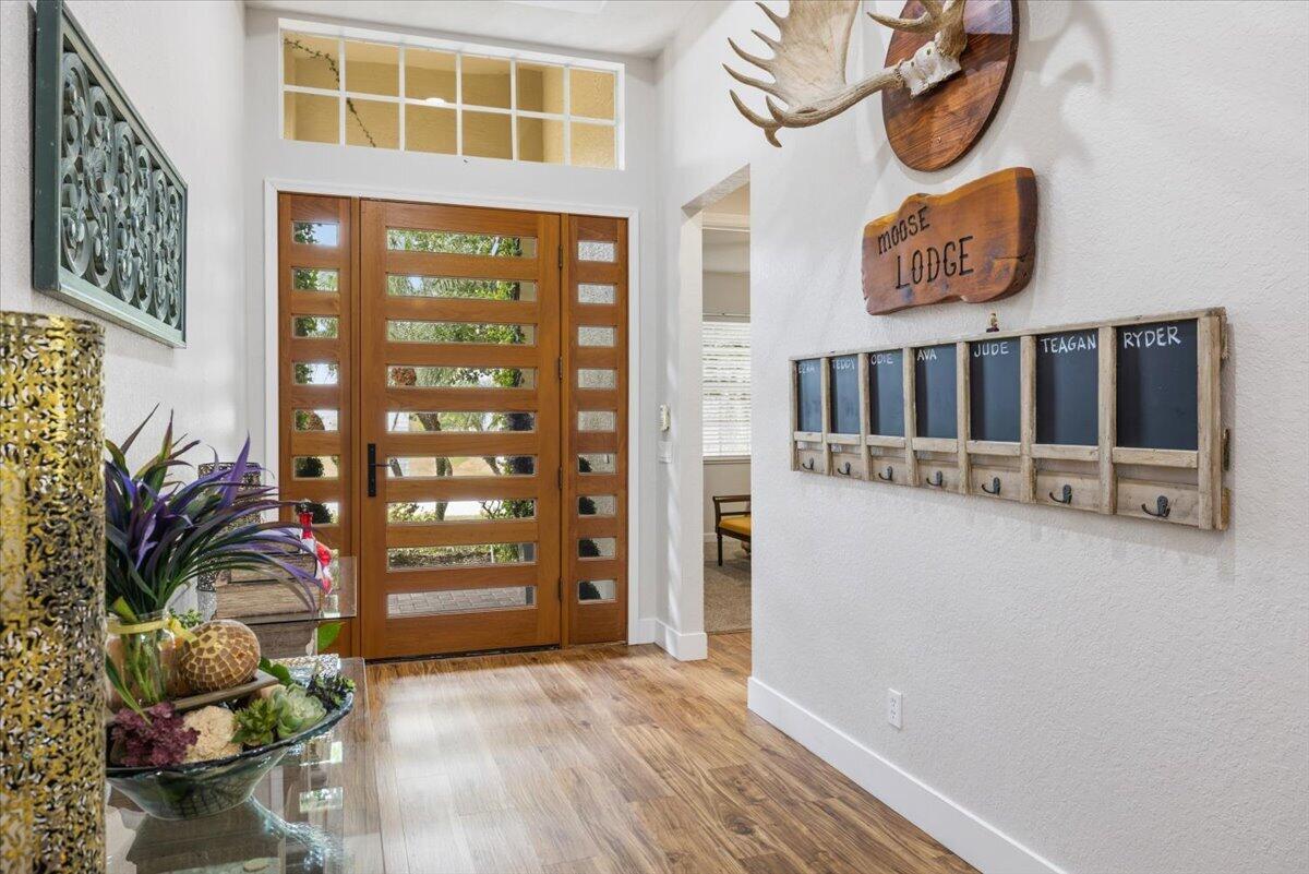 An entryway features a wood front door, a moose mount, and a personalized coat rack — 5185 Topaz Lane SW, Vero Beach FL 32968, VERO BEACH, FL