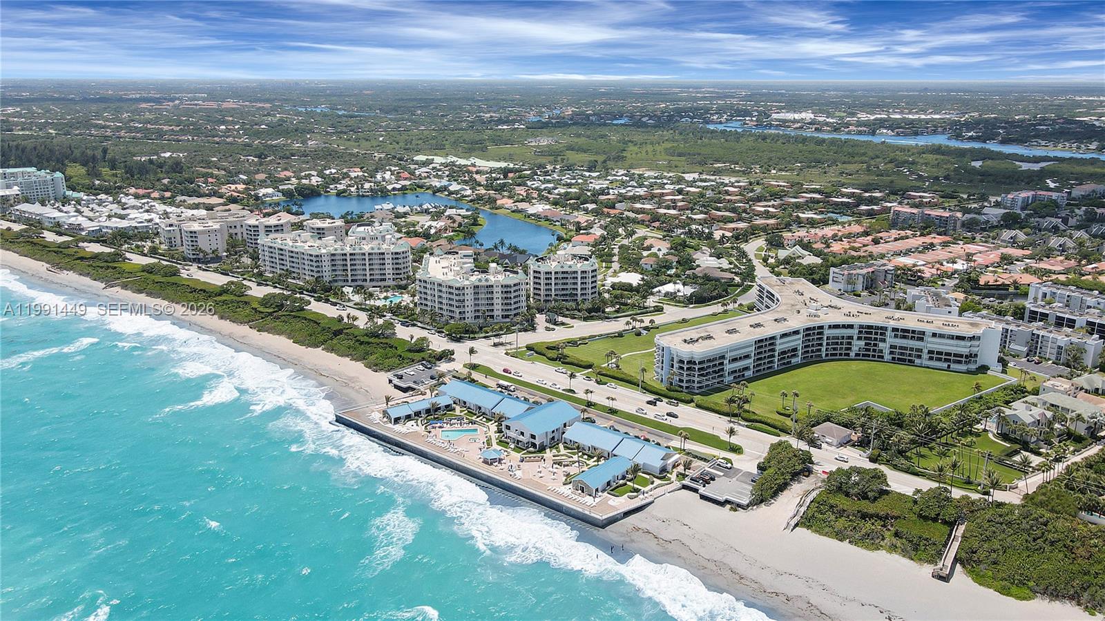 An aerial view shows beachfront condominiums, a clubhouse with a pool, and surrounding residential neighborhoods — 1300 S Highway A1a # 402, Jupiter FL 33477, JUPITER, FL