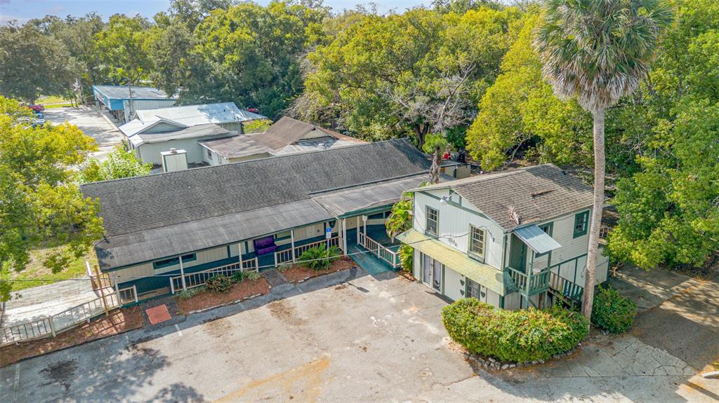 An aerial view shows two adjacent buildings with dark shingled roofs and a parking lot — 2516 SANFORD AVENUE, SANFORD, FL