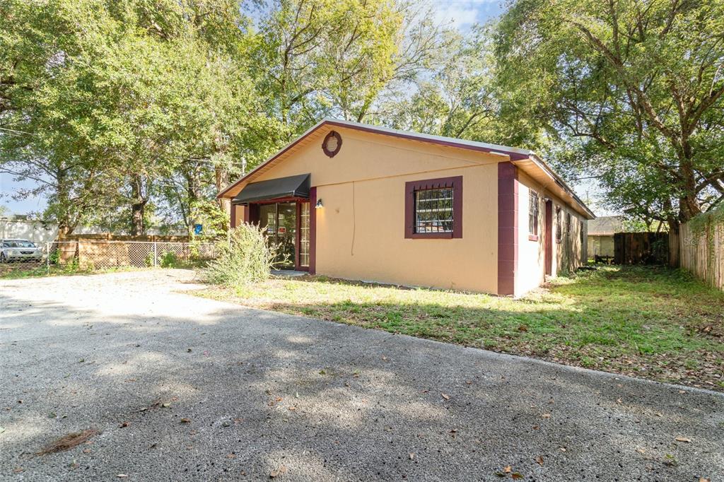 A tan, single-story building with a dark-trimmed window and a small entrance awning — 2516 SANFORD AVENUE, SANFORD, FL