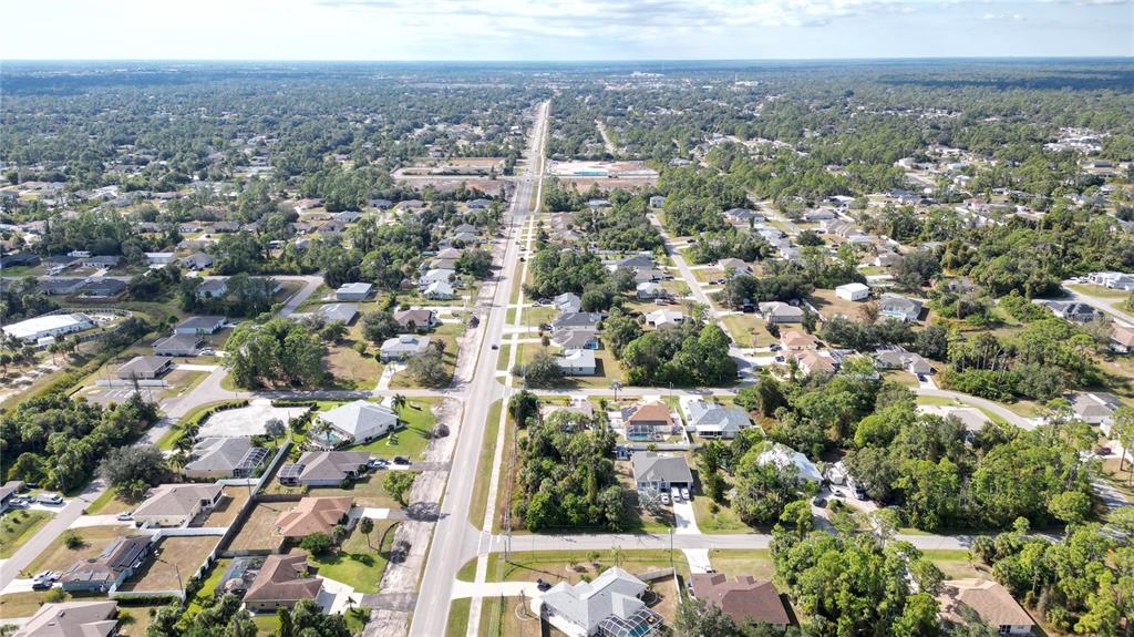 An aerial view shows a residential neighborhood with houses, trees, and a central road — 0 W PRICE BOULEVARD, NORTH PORT, FL