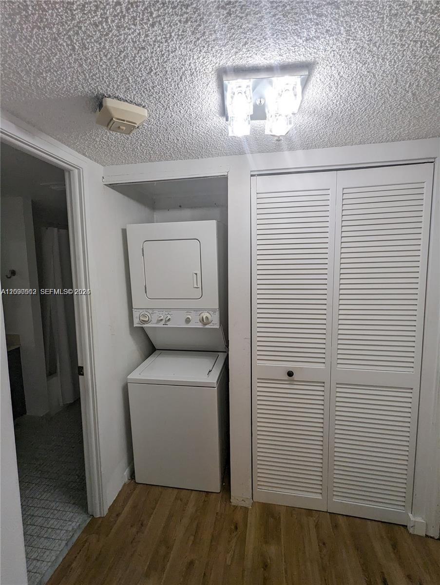 A laundry area features a stacked washer and dryer unit next to a louvered closet — SUNNY ISLES BEACH, FL